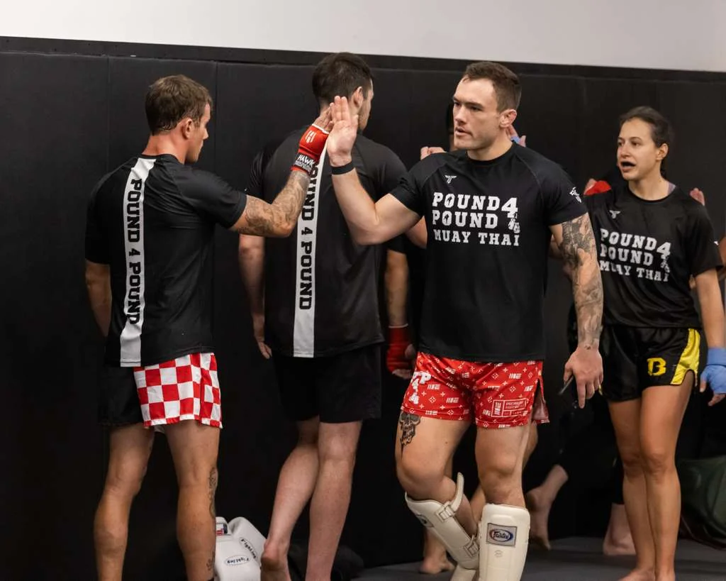 Pound 4 Pound Muay Thai class lined up with a coach in the Littleton gym